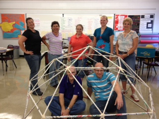Dr. Olsen sitting in a Newspaper Geodesic Dome