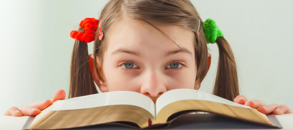 girl looking over open book