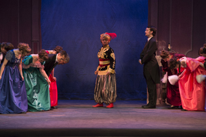 Party guests bow to a woman in a turban.