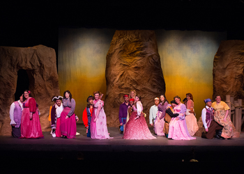 A large group of pirates and women look at the camera.