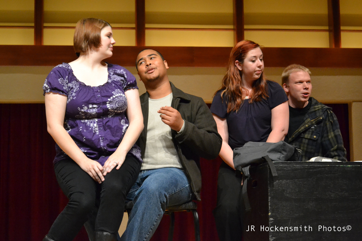 Two men are seated singing, each to a woman seated on on his lap.