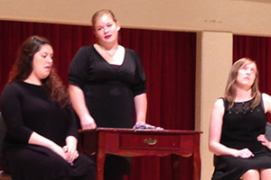 Two women dressed as cats sing.