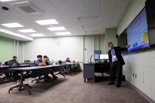 Tahir Khan, Associate Professor of Cybersecurity and Interim Director of the WIU Cyber Security Center, talks with students taking the STEM summer camp at WIU in July.