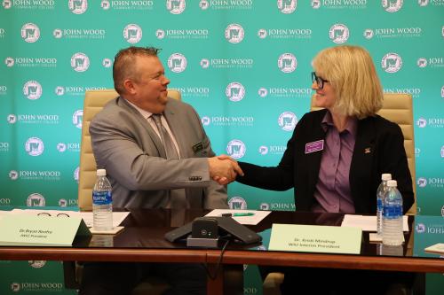 John Wood Community College president, Bryan Renfro, and WIU Interim President, Kristi Mindrup, shake hands after establishing a transfer pathway for students pursuing a degree in criminal justice/law enforcement.