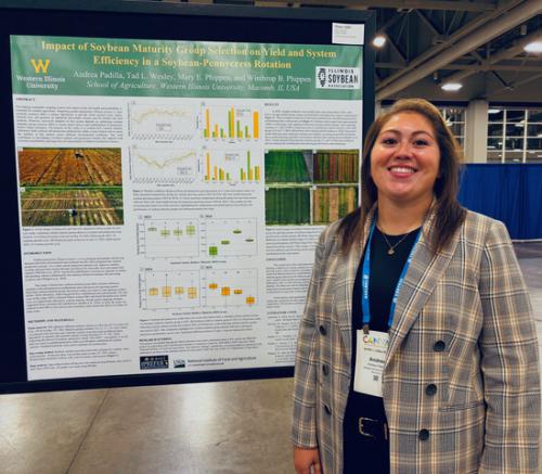 Andrea Padilla stands next to her research poster in the cropping systems division, which earned her first place. 
